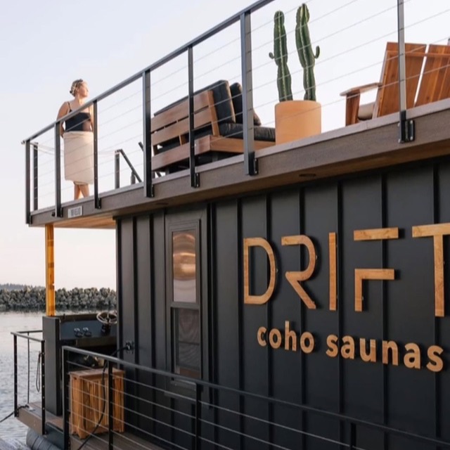 A guest wrapped in a towel on the rooftop deck of the Drift sauna boat